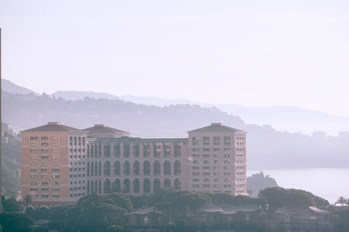 绿树附近的棕色混凝土建筑 · 免费素材图片