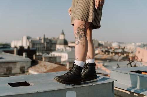 黑色的皮靴，坐在灰色的混凝土栏杆上的女人 · 免费素材图片