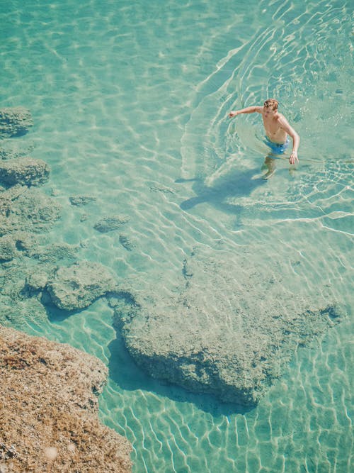 泳装的匿名游人在用纯净的水的海洋 · 免费素材图片