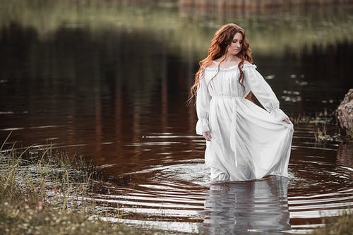 体贴的女子站在湖水中 · 免费素材图片