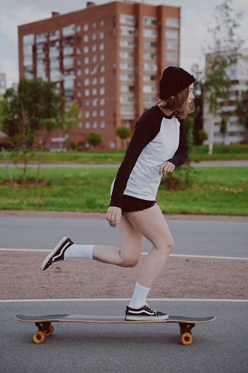 红色和白色的长袖衬衫和黑色的裙子，在路上跑的女人 · 免费素材图片