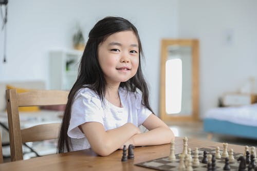 下棋在明亮的房间里的亚洲女孩 · 免费素材图片