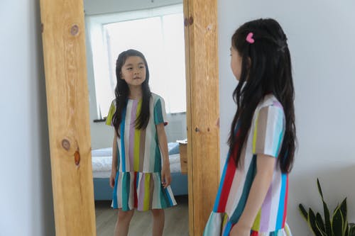 看有木材框架的可爱的亚裔女孩镜子 · 免费素材图片
