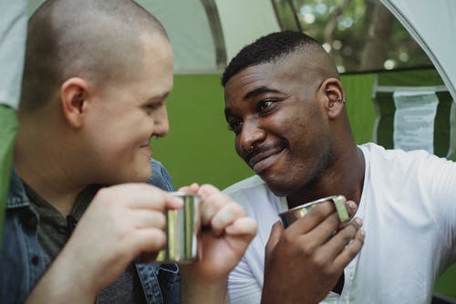 积极多种族的同性夫妇在帐篷里喝茶 · 免费素材图片
