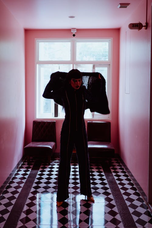 黑色西装站在走廊上的非正式时髦女人 · 免费素材图片
