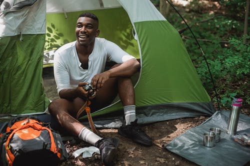 放松在帐篷里的愉快的黑人在森林里 · 免费素材图片