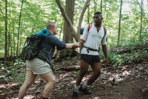 坚强的黑人帮助朋友攀爬 · 免费素材图片