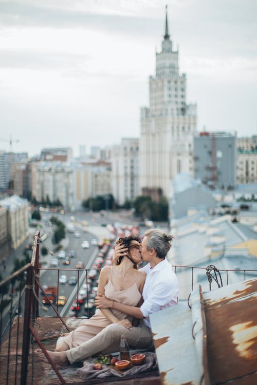 时尚情侣接吻在现代城市的屋顶上 · 免费素材图片
