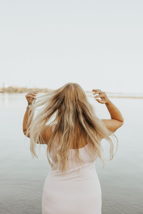 在风平浪静的海滩上的女人 · 免费素材图片