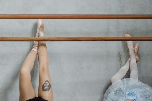 躺在地板上，腿在墙上的年轻芭蕾舞演员 · 免费素材图片