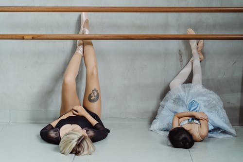 芭蕾舞女演员在舞蹈工作室的地板上休息 · 免费素材图片