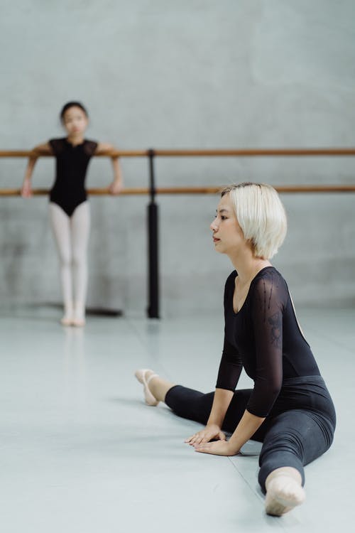 拉伸与工作室里的女孩的民族芭蕾舞演员 · 免费素材图片