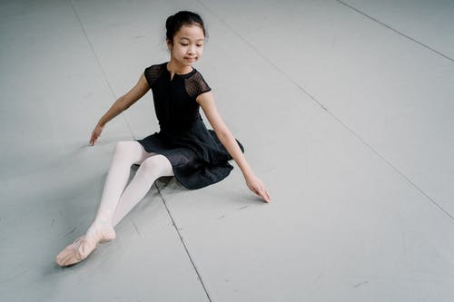 优雅的亚洲女孩芭蕾舞女演员坐在工作室的地板上 · 免费素材图片