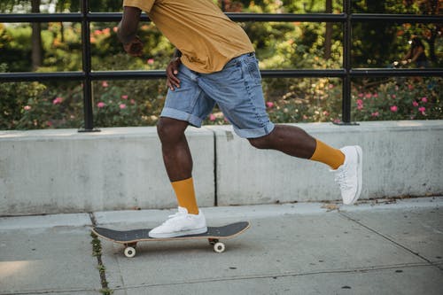 在白天的街道上的非洲裔美国滑板骑滑板 · 免费素材图片