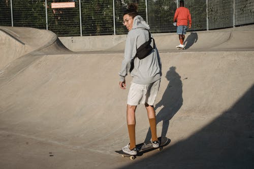 踩滑板在现代舷梯的正面年轻人在晴天 · 免费素材图片