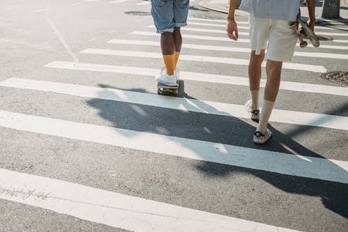 不同的男性朋友，与滑板过马路在城里 · 免费素材图片