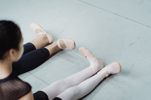与学生在地板上练习芭蕾舞练习的作物教练 · 免费素材图片