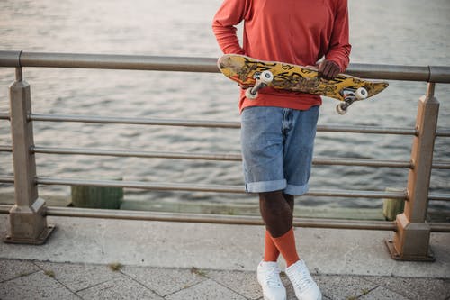 有在堤防上的滑板的年轻黑人 · 免费素材图片
