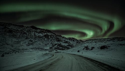 雪覆盖的山，在绿色的天空下 · 免费素材图片