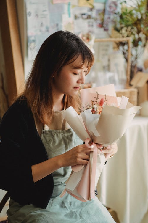 族裔女人与温柔的鲜花在车间 · 免费素材图片