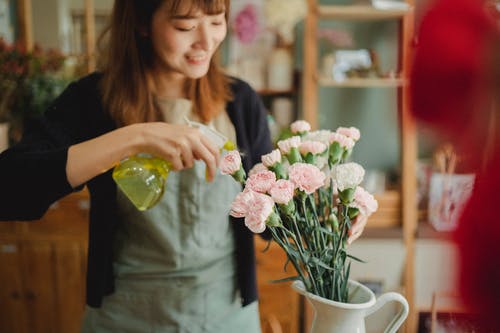 亚洲女人在店里喷花 · 免费素材图片