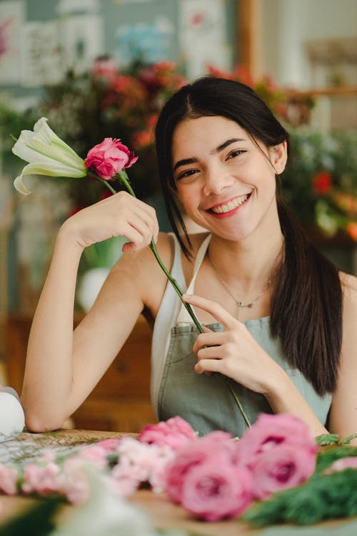 微笑的花店在店里制作束鲜花 · 免费素材图片