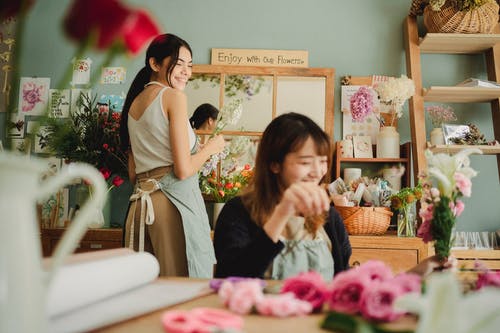 微笑在鲜花间工作的不同妇女 · 免费素材图片