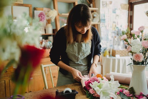 女人在店里做花香 · 免费素材图片