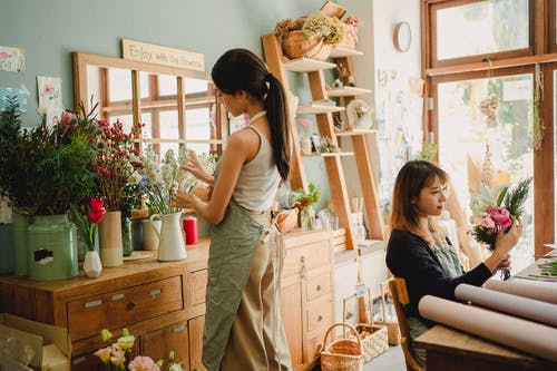 集中各种妇女在花卉市场上制作花卉组成 · 免费素材图片