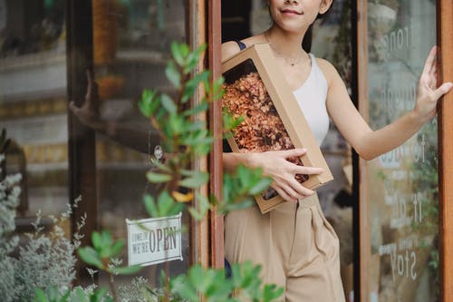 有离开花店的干花箱子的庄稼高兴妇女 · 免费素材图片