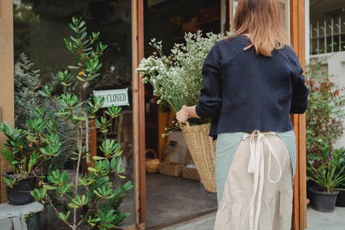 作物不可识别的女人提着一篮植物 · 免费素材图片