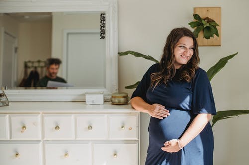 在家反射在镜子的微笑的孕妇和丈夫 · 免费素材图片