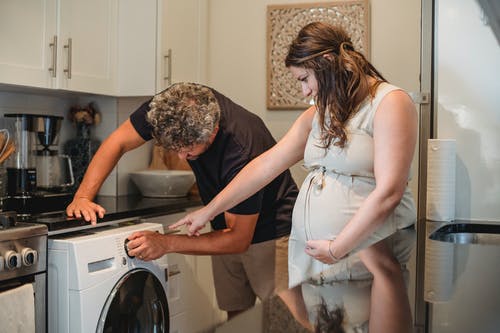 丈夫帮助妻子洗衣服 · 免费素材图片