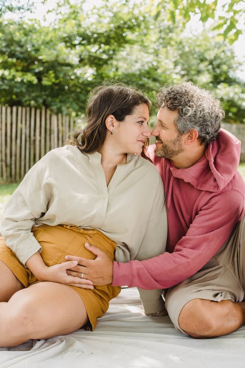 孕妇和男人坐在格子上 · 免费素材图片