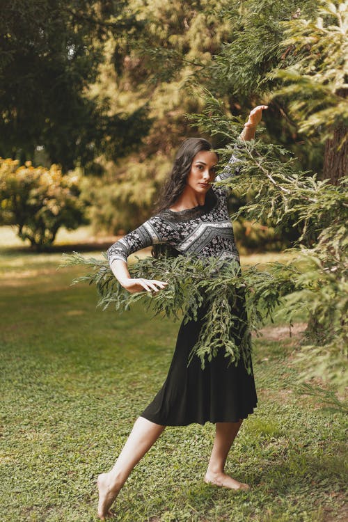 优雅赤脚年轻黑发跳舞附近公园里的树 · 免费素材图片