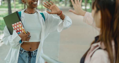 快乐的黑人妇女打招呼要走道上的女友 · 免费素材图片