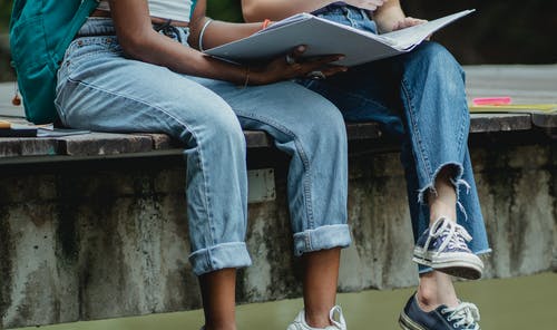 播种不露面的多样化女学生在公园码头上读教科书 · 免费素材图片