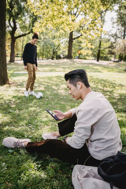 族裔人在公园里浏览智能手机 · 免费素材图片