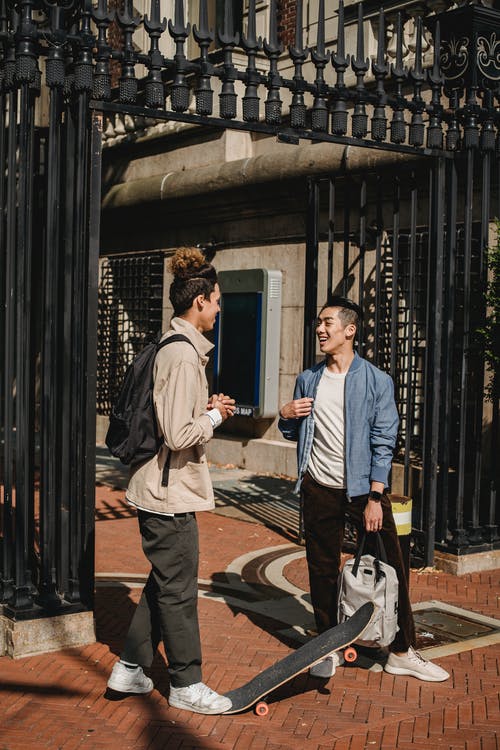 两个年轻人站在黑门的面前 · 免费素材图片