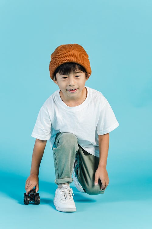 白色圆领t恤和橙色针织帽的男孩 · 免费素材图片