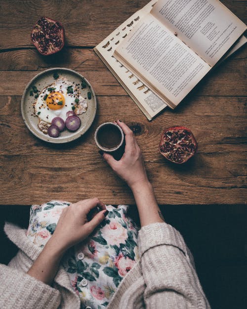 作物女人吃早餐和阅读 · 免费素材图片