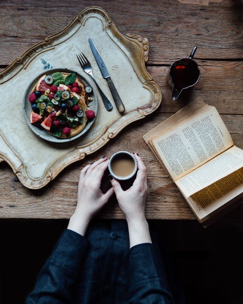 作物女人吃早餐和阅读 · 免费素材图片