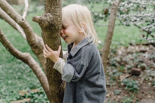 站在树旁边的灰色外套的女孩 · 免费素材图片