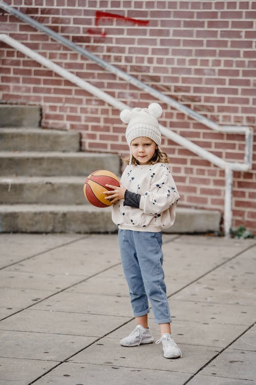 白色外套和蓝色的裤子，拿着篮球的孩子 · 免费素材图片