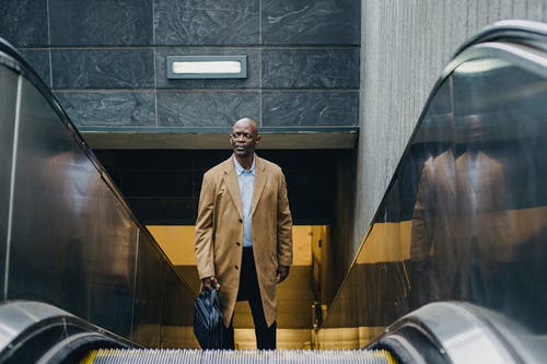 在城市的自动扶梯上的男性种族高管 · 免费素材图片