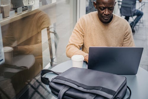 手提电脑在街边咖啡馆有信心黑人企业家 · 免费素材图片