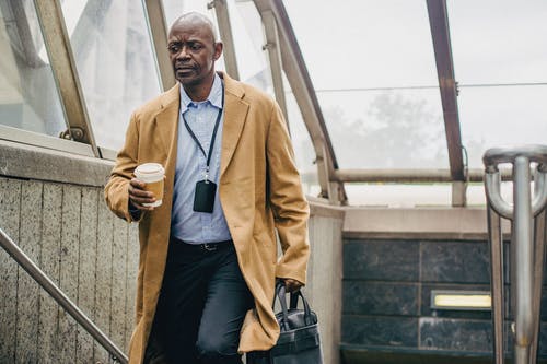 考虑黑人男性经理喝咖啡上楼梯 · 免费素材图片