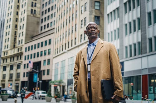 男性黑人上班族对城市中的多层建筑 · 免费素材图片