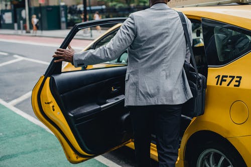 出租车出租车不露面的黑人男子开门 · 免费素材图片