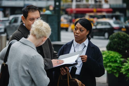 多族裔同事站在城市街道上的文件 · 免费素材图片